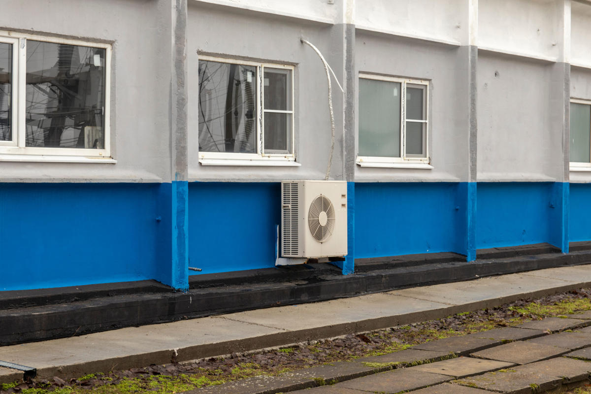 Air conditioning condenser and piping on building wall