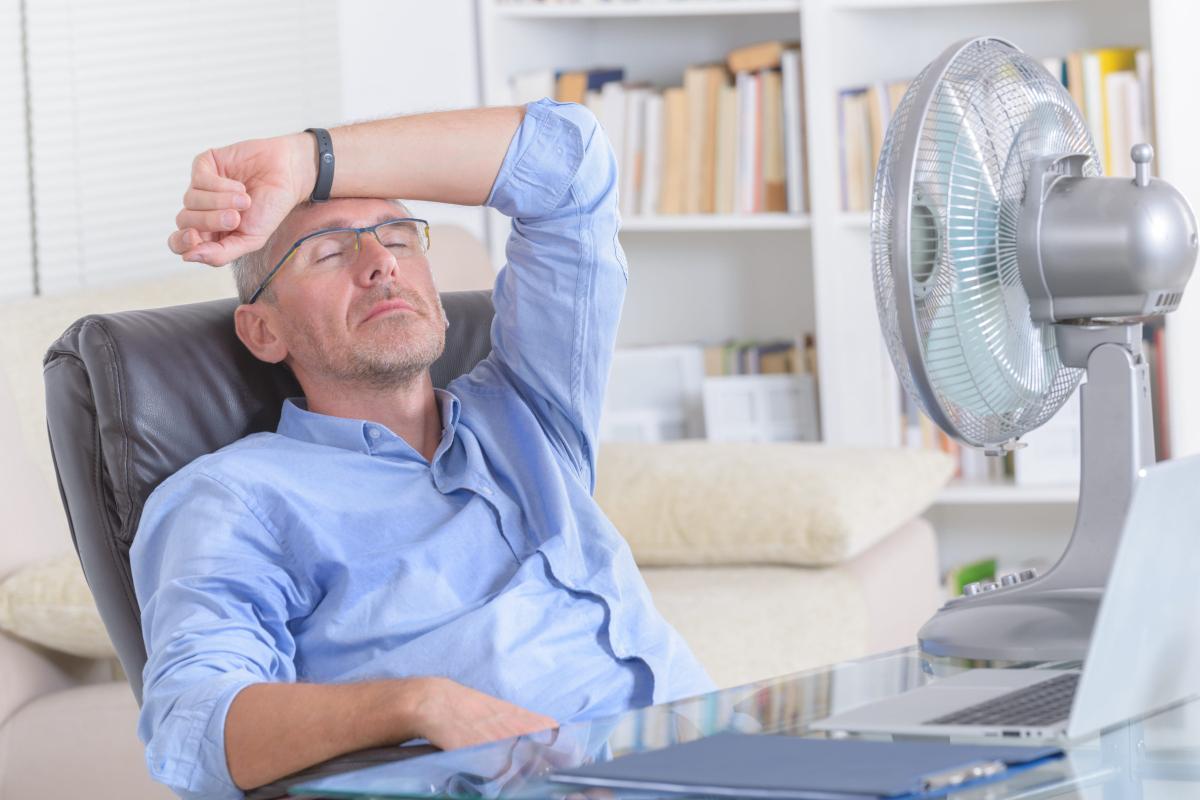 Man cooling of with a fan.